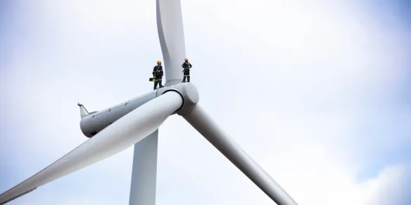 Maintenance technician working on huge wind turbine
